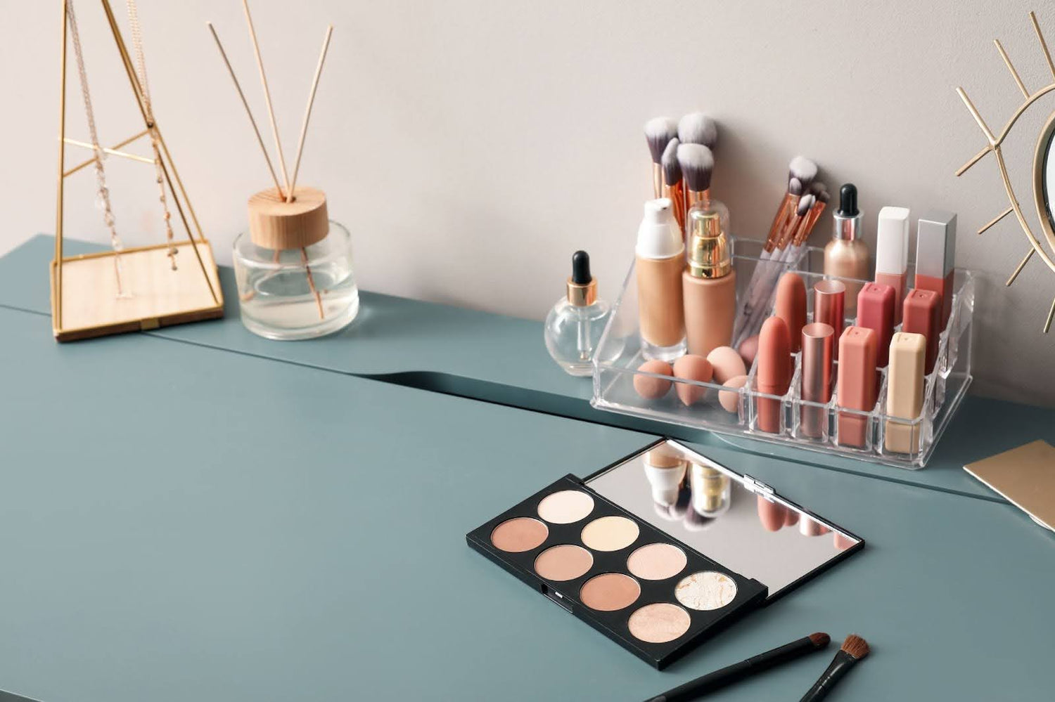 Makeup products neatly arranged on a desk and in makeup organizers, showcasing how to organize makeup. 